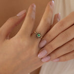 Emerald and yellow gold granulated ring on hand