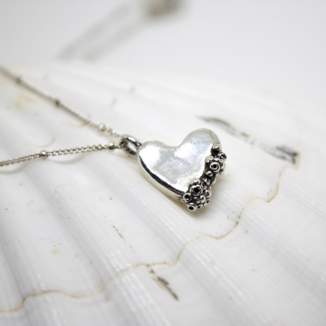 Silver heart pendant necklace with barnacle-inspired texture and oceanic design