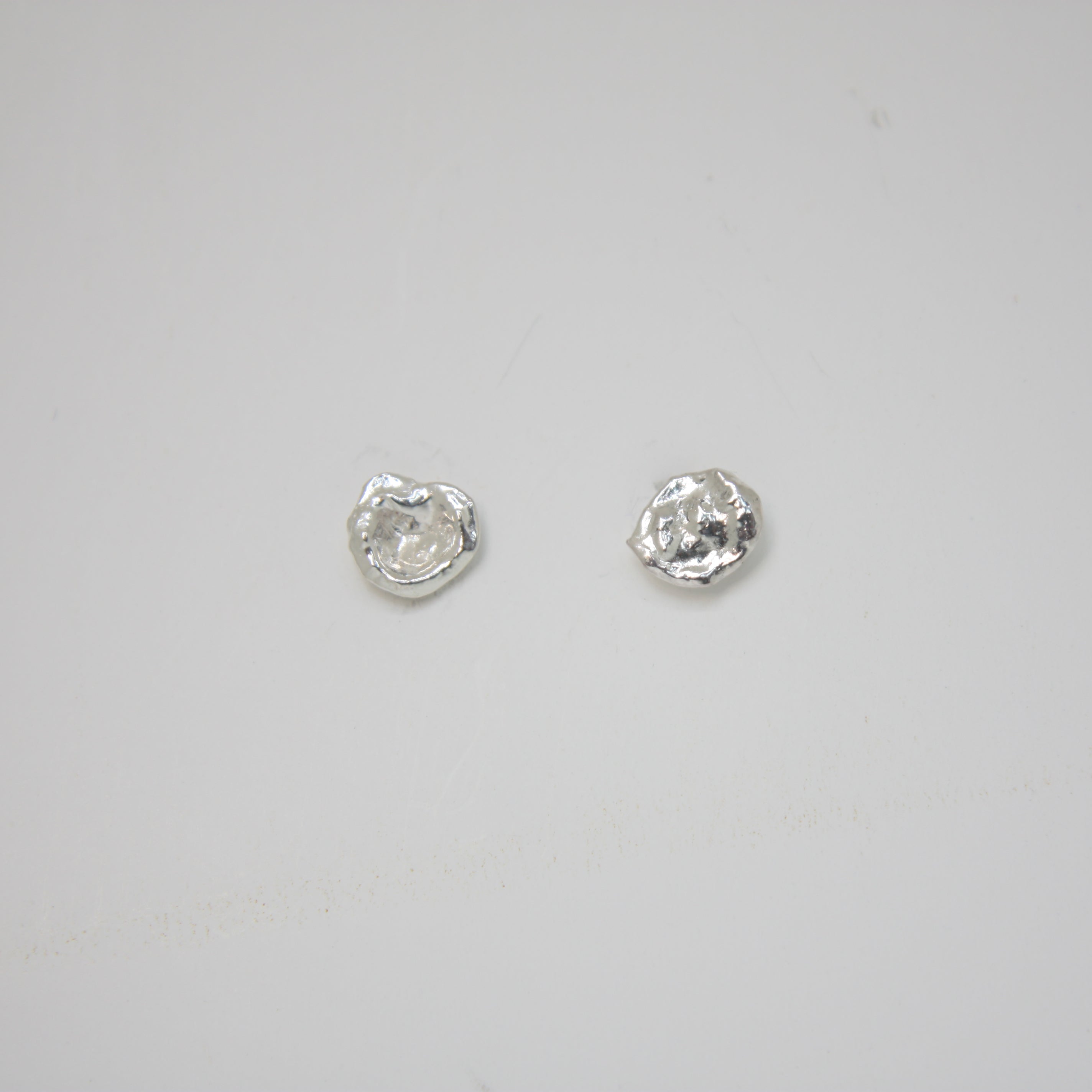 Organic molten silver stud earrings with a textured, modern finish