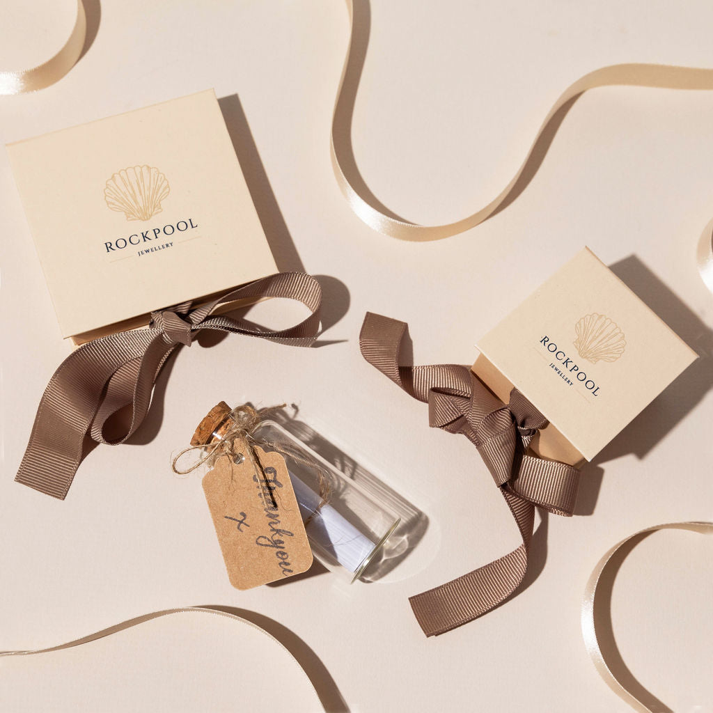 Eco-friendly jewellery gift packaging from Rockpool Jewellery with cream boxes, grosgrain ribbon, and coastal-inspired thank-you message