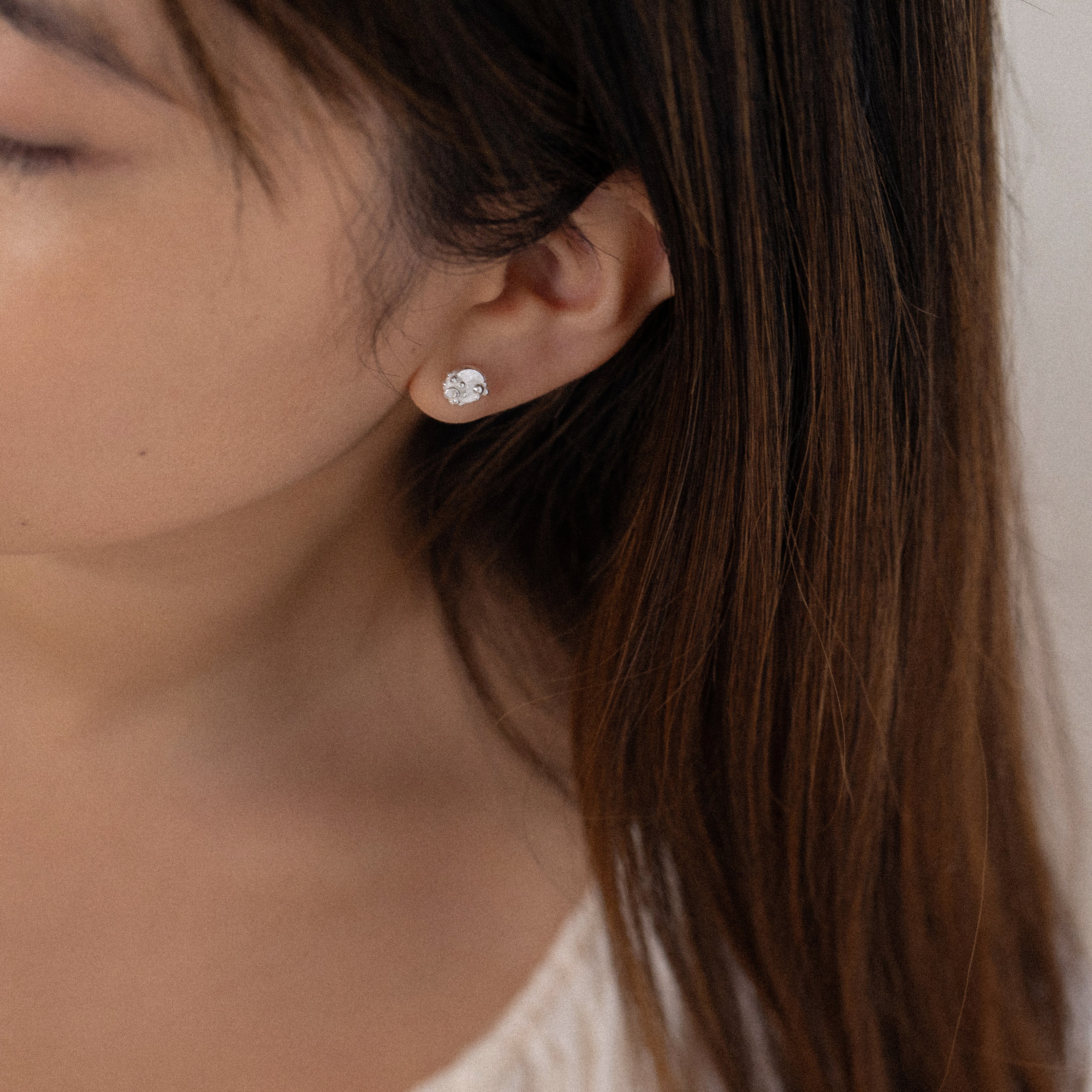Woman wearing sterling silver organic stud earrings by Rockpool Jewellery, nature-inspired studs for beach lovers and everyday wear