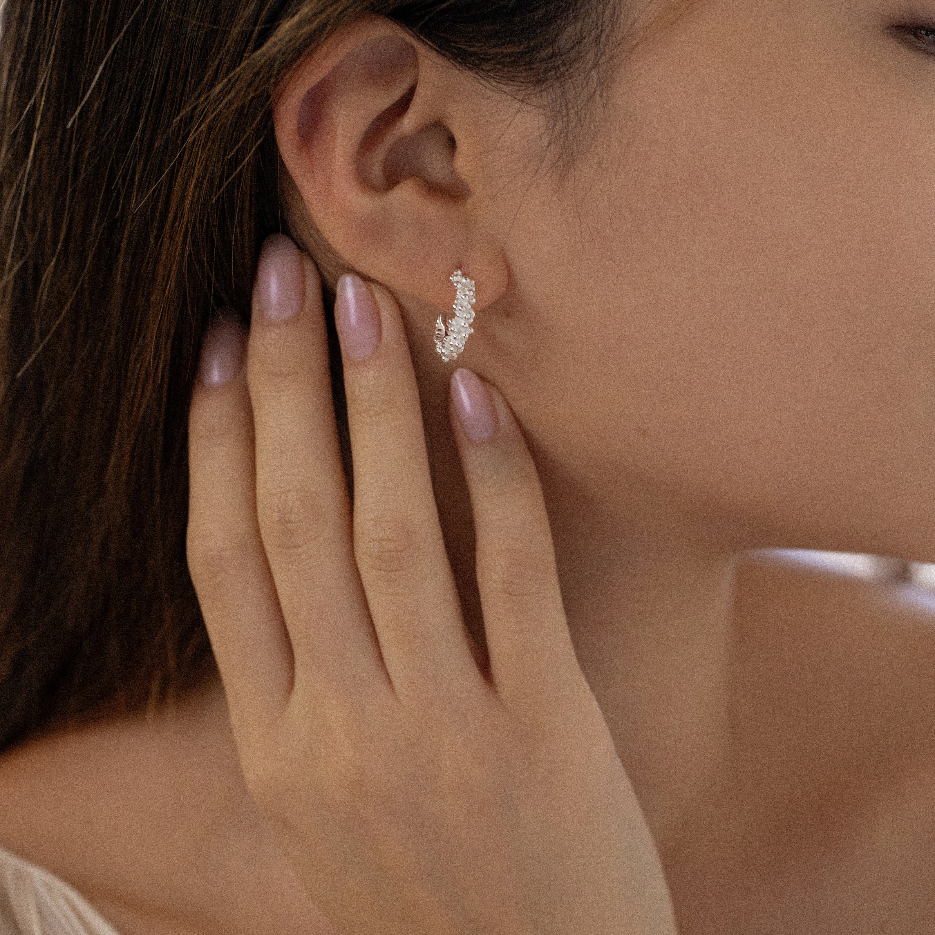 Woman wearing Rockpool Jewellery’s sterling silver bubble hoop earrings, lightweight modern design inspired by the sea