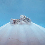 Silver earrings with a blue background on a white shell