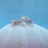 Silver earrings with a blue background on a white shell