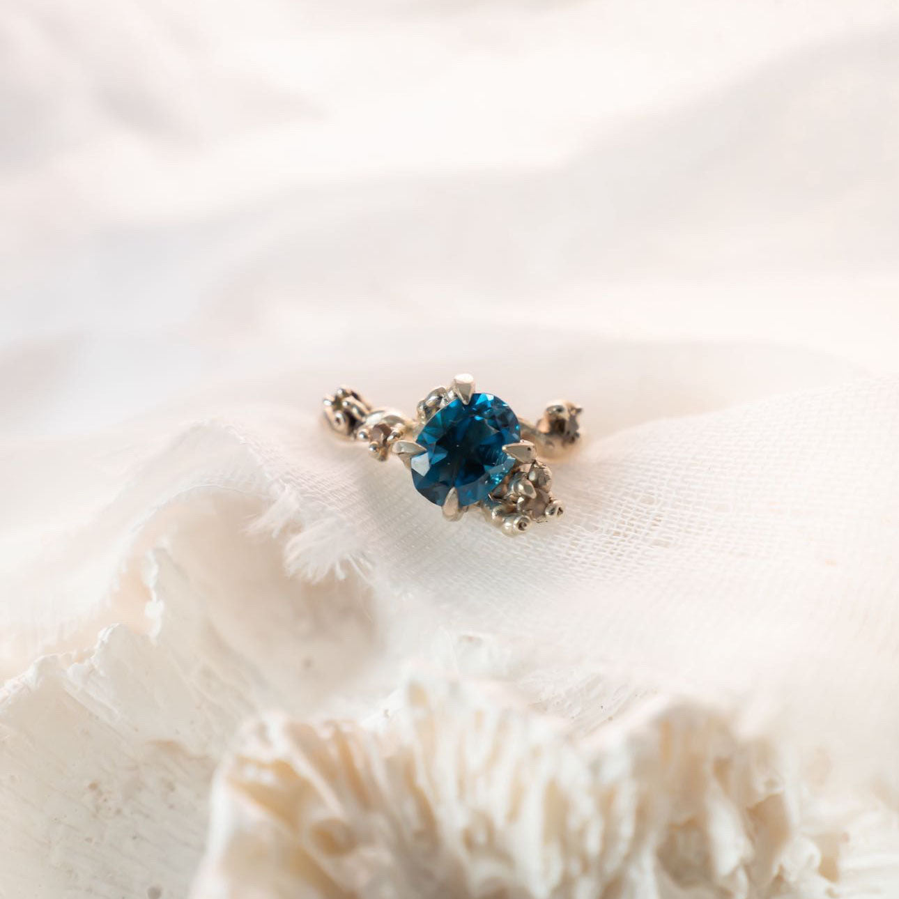 Blue stone ring on cream linen fabric