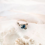 Blue stone ring on white fabric background