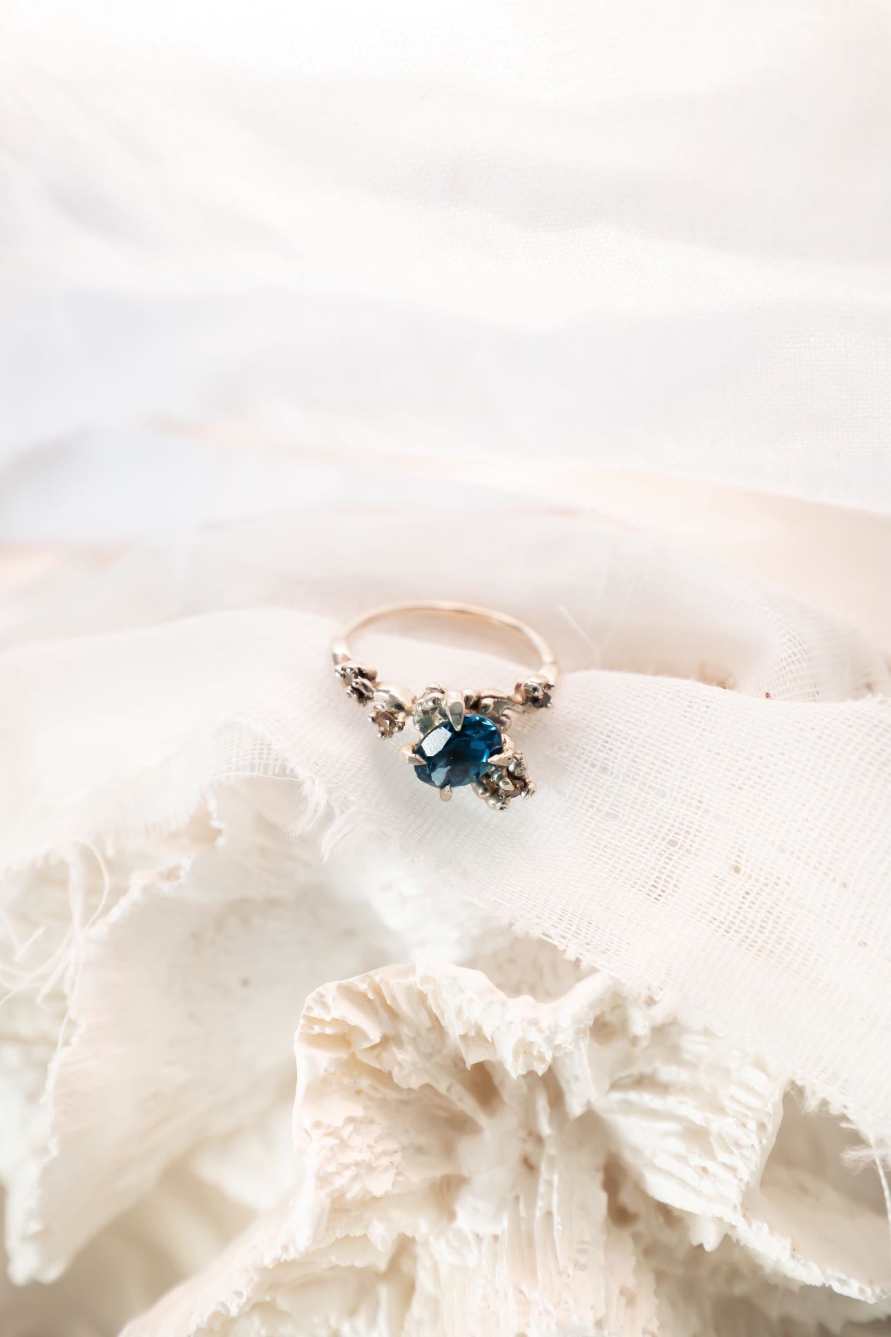 Blue stone ring on white fabric background