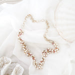 Pearl necklace on a white surface with shells