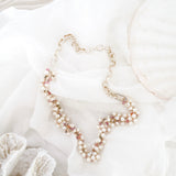 Pearl necklace on a white surface with shells