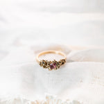 Gold ring with pink stone on white fabric