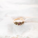Gold ring with pink stone on white fabric
