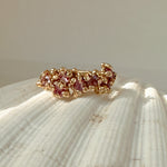 Gold ring with pink stones on a shell