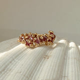 Gold ring with pink stones on a shell