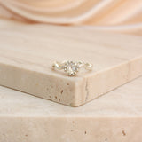 Rose cut diamond solitaire ring with wavey silver coloured gold band on a stone background