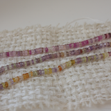Colorful beaded strands on a textured fabric background
