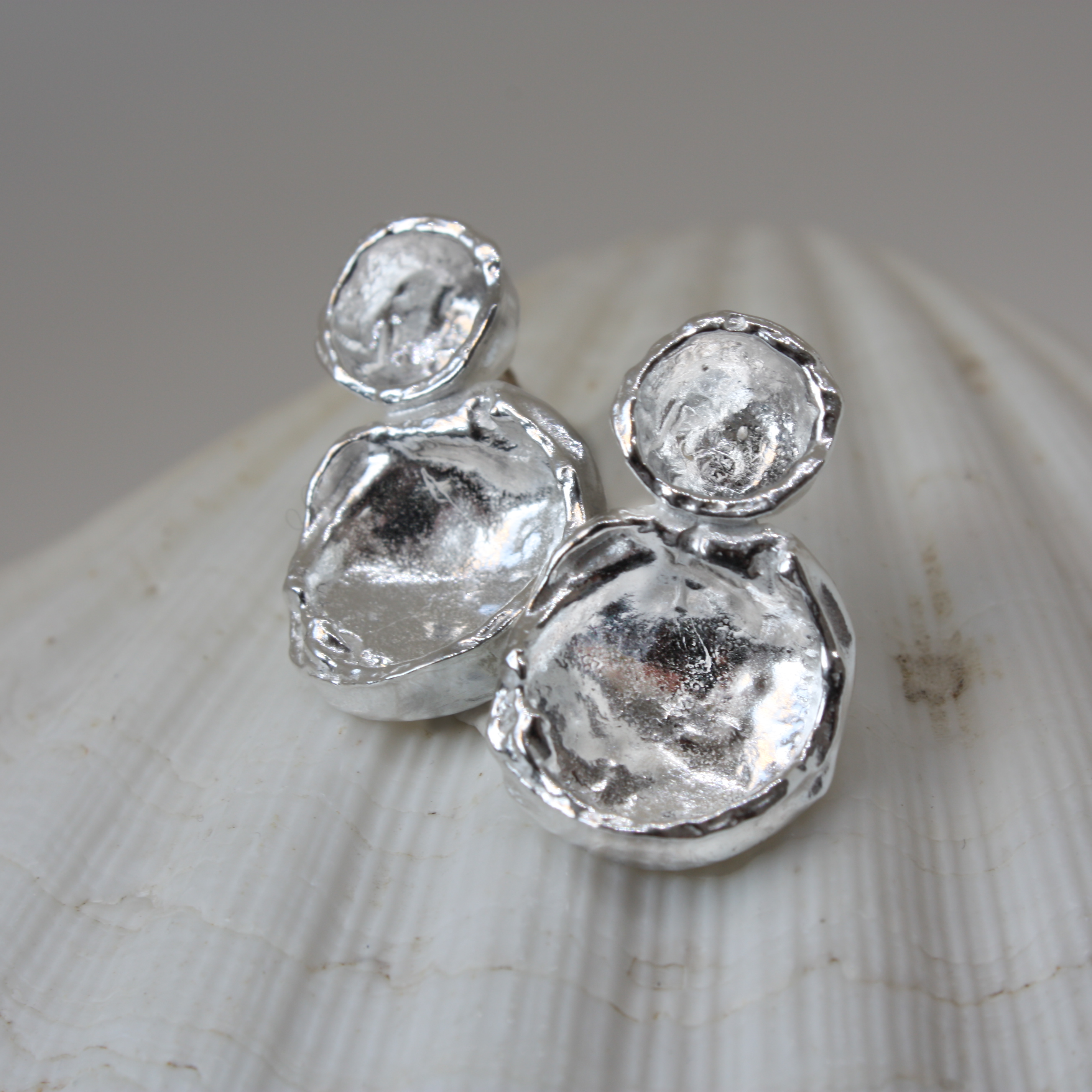 Silver earrings on a shell background