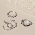 Rockpool Jewellery Ocean Collection featuring sterling silver hoop earrings and two organic wave-inspired silver rings, photographed on neutral background